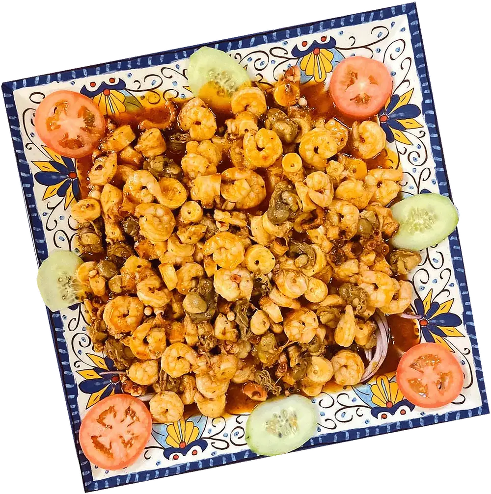 A platter of seasoned shrimp with tomato and cucumber